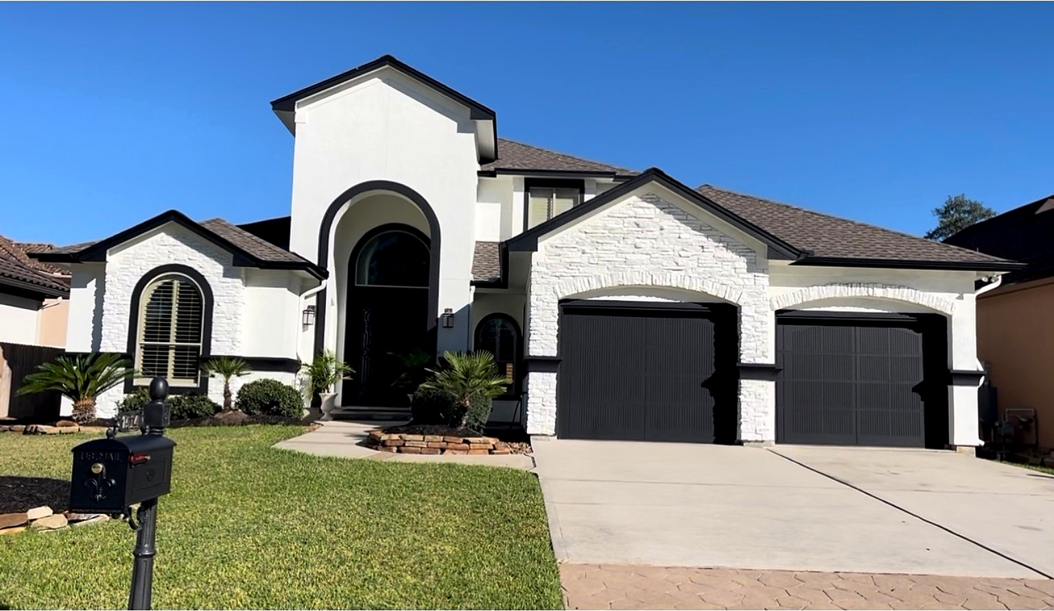 Completed residential exterior transformation with white finish and dark trim