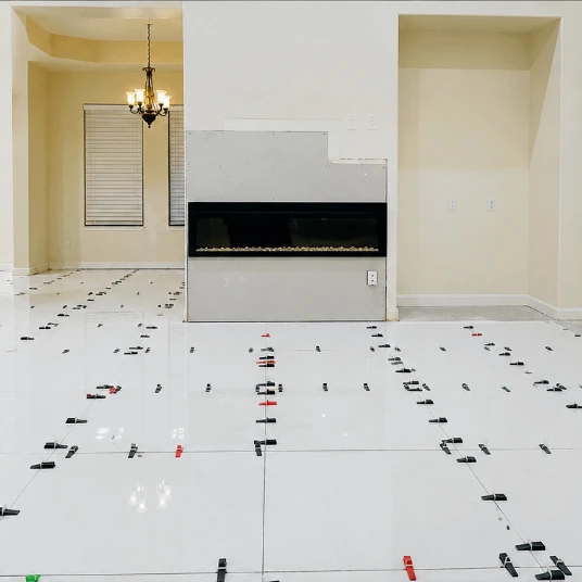 Tile installation with leveling clips and linear fireplace in progress